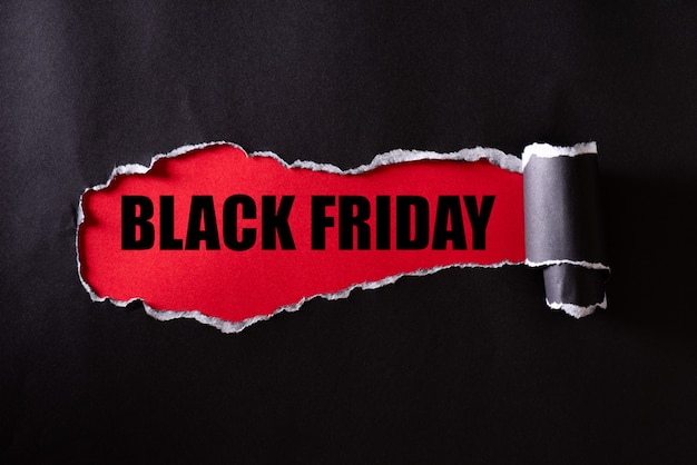 Carta strappata nera e testo Black Friday su rosso