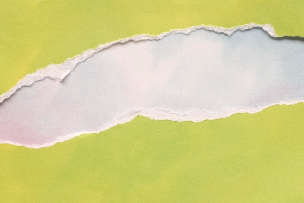 Carta verde limone strappata su sfondo blu cielo bianco