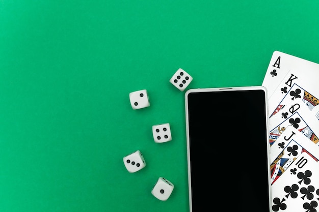 Carte da gioco poker dadi e telefono su panno verde blu