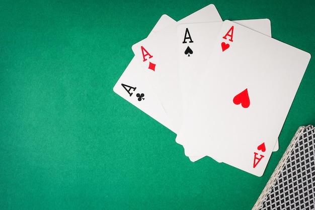 Carte da gioco Quattro assi su sfondo verde Spazio libero per il testo