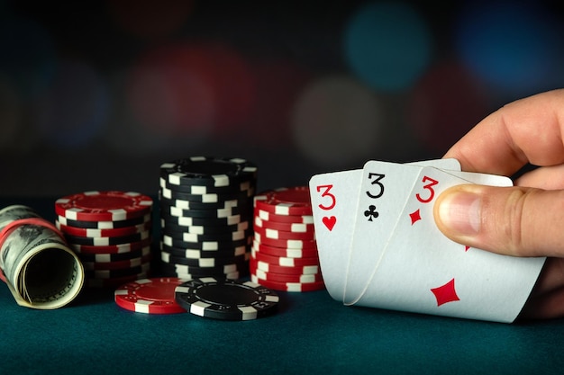 Carte da poker con tre di un tipo o una combinazione di set La mano del giocatore detiene una combinazione vincente in una partita in un club di poker