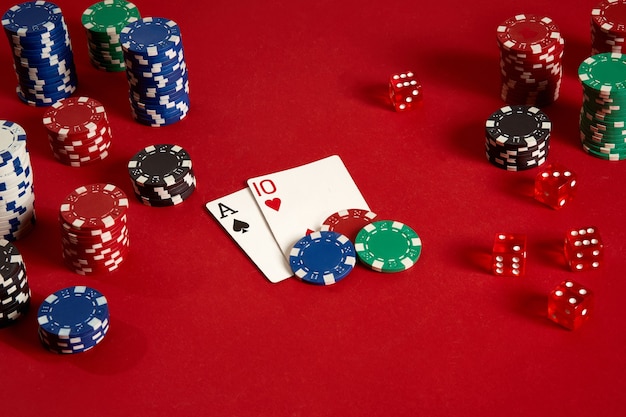 Carte da poker e gettoni da gioco su sfondo rosso. Vista dall'alto. Copia spazio. Natura morta. Disposizione piatta. Carte - Asso e Dieci