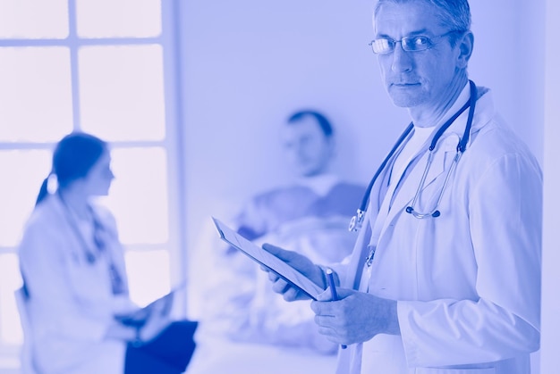 Cartella della holding del medico davanti a un paziente e un medico