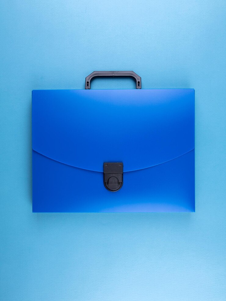 Foto cartella in plastica blu per documenti e articoli scolastici su un tavolo blu brillante