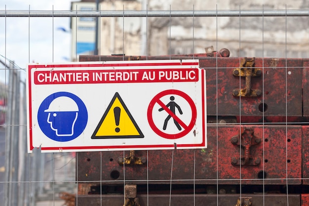 Cartello francese su una recinzione che indica Non entrare in cantiere