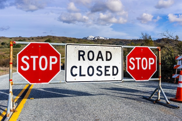 Cartello stradale chiuso pubblicato su Mt Hamilton road a causa della neve South San Francisco Bay Area California neve visibile sulla vetta sullo sfondo