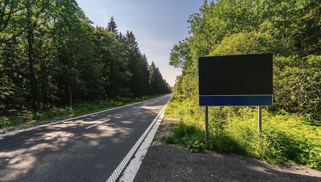 Cartello stradale vuoto in strada nel copyspace dei boschi per il tuo testo individuale