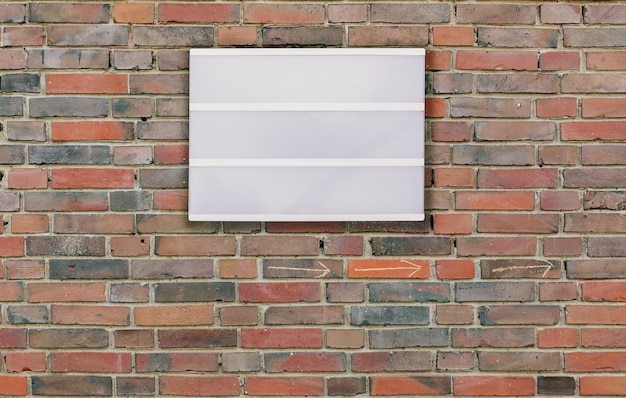 Cartellone bianco sulla parete di mattoni