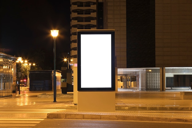 Cartellone con luce nel centro della città di notte