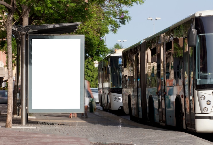 Foto cartellone in centro città con bus in movimento