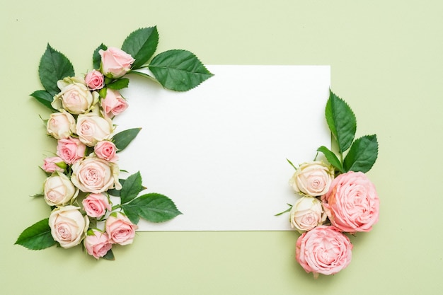 Cartolina d'auguri di festa o nota sul tavolo verde. Decorazioni con cornice rosa. Lay piatto.