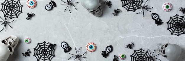 Cartolina d'auguri di Halloween con banner di teschi di zucca e ragni