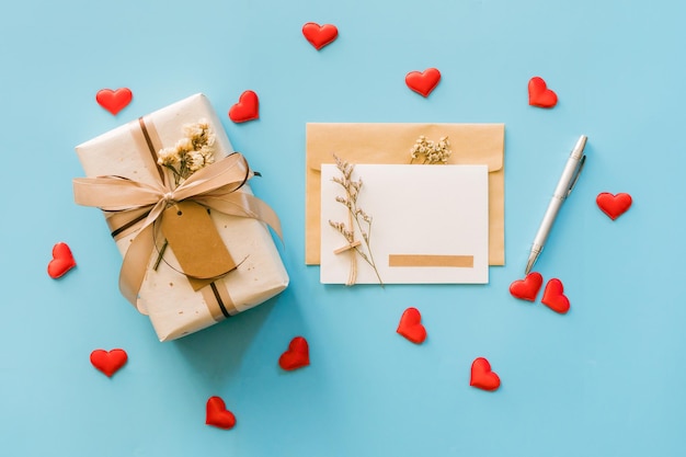 Cartolina d'auguri e scatole regalo con cuore rosso su sfondo blu, copia spazio per il testo
