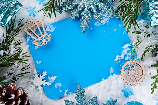 Cartolina di Natale con albero di abete decorato sulla neve.