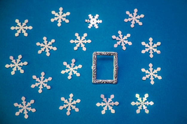 Cartolina di Natale con cornice e fiocchi di neve su sfondo blu