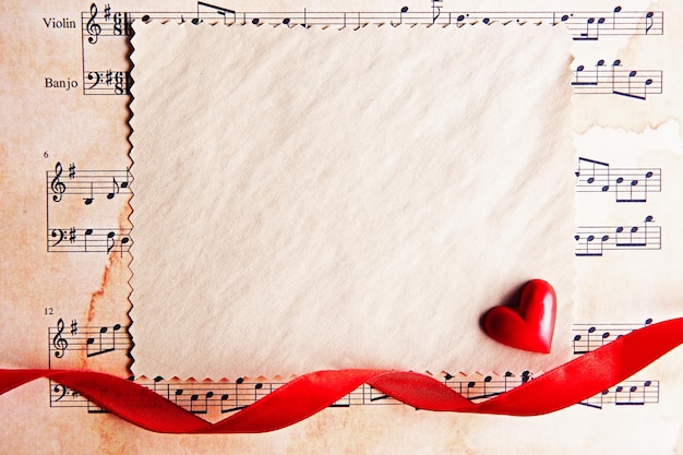 Cartolina di San Valentino presente in bianco su sfondo di spartiti musicali