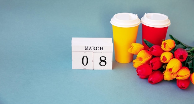 Cartolina per l'8 marzo Un bouquet di tulipani bicchieri di caffè e un calendario con la data Con spazio per la copia