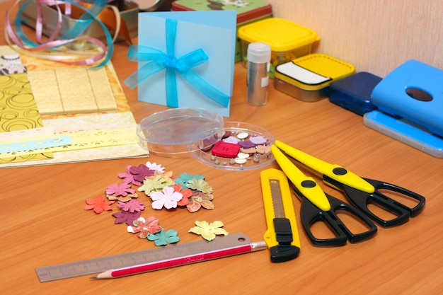 Cartolina scrapbooking fatta a mano e strumenti sdraiati su un tavolo