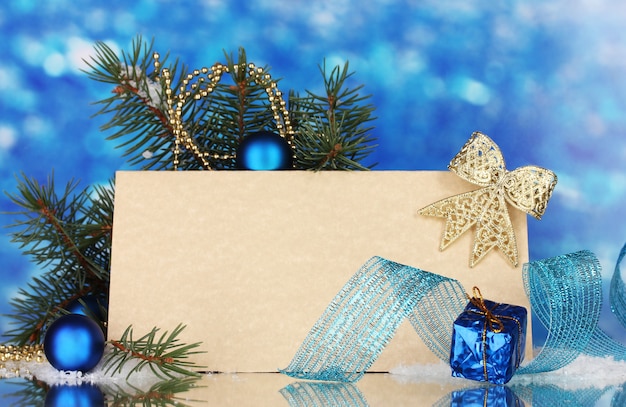 Cartolina vuota, palle di Natale e abete su sfondo blu blue