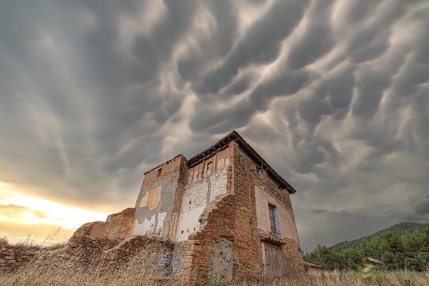 Casa abbandonata in campagna con tempesta cumulus sky