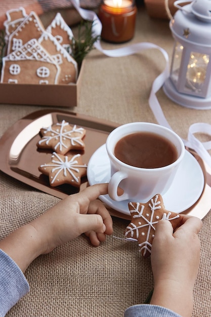 Casa accogliente di Natale Bambino che fa colazione con cacao e biscotti di panpepato di Natale Cottura invernale atmosferica