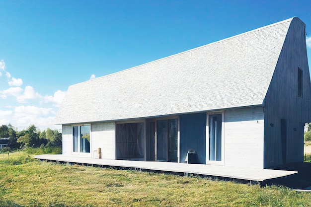 Casa bianca a un piano nel mezzo del prato esterno della casa in stile scandinavo