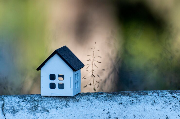 Foto casa bianca con tetto nero e sfondo verde sfocato, per immobili, con spazio per posto te