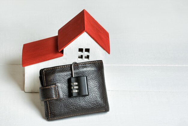 Casa con borsa e lucchetto. Acquisto sicuro di una casa. Immobiliare, mutuo.