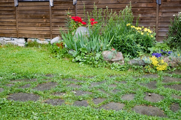 Casa con gigli, rose, aster e altri fiori