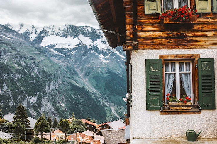 Foto casa con persiane alle finestre fioriere annaffiatoio chalet vicino alle montagne della jungfrau switzerland