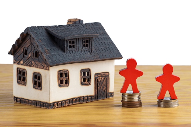 Casa con pile di denaro e un modello di figura che simboleggia l'aumento dei prezzi degli immobili