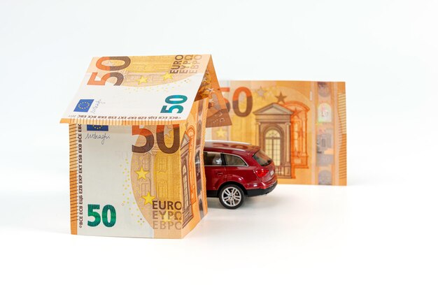 Casa da banconote in euro e concetto di assicurazione auto e prestito immobiliare isolato per auto