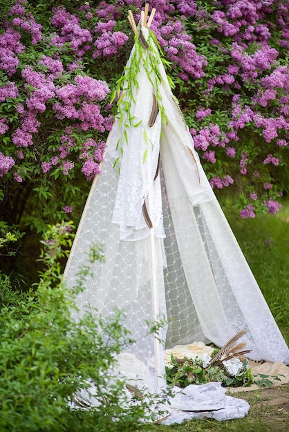 Casa decorativa Wigwam in lillà naturale e verde in un parco o forestaxA