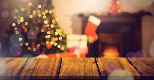 Casa di Natale con albero e calza e superficie in legno con luci bokeh