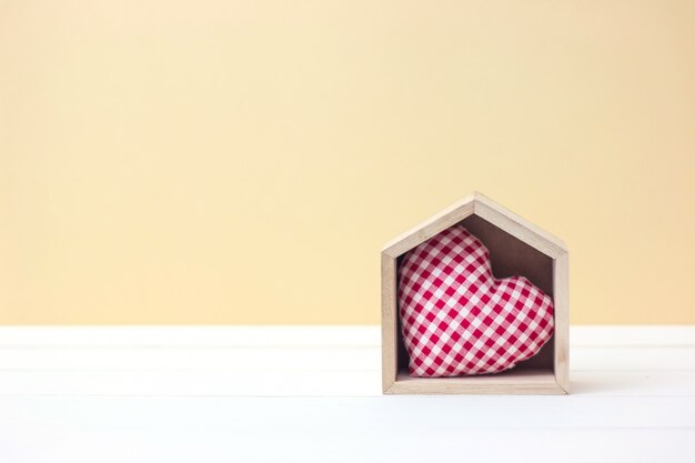 Casa dolce casa. Il concetto di San Valentino con forma del cuore in casa di legno con lo spazio della copia.