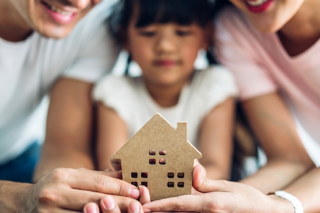 Casa felice della tenuta della famiglia nel concetto del bene immobile