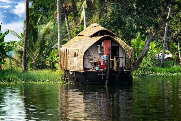 casa galleggiante tradizionale è ancorata sulle rive di un lago da pesca in India.