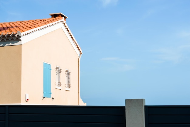 Casa gialla sulla vista laterale del fondo del cielo blu