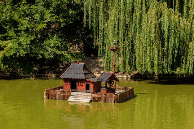 Casa in legno per uccelli acquatici e tartarughe su un lago nel parco cittadino