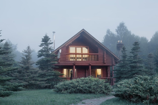 Casa in legno tra gli alberi all'alba d'estate