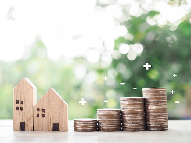 Casa in miniatura e pila di monete Il concetto di risparmio di denaro per la casa Investimenti immobiliari Mutuo per la casa Immobiliare
