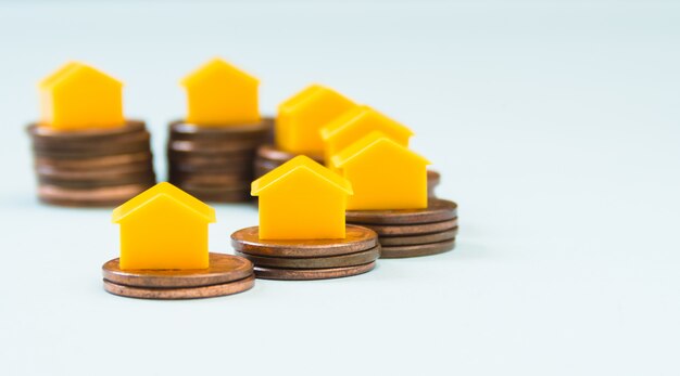 Casa in miniatura su pile di monete da 1 Cent, immobiliare e concetto di finanza