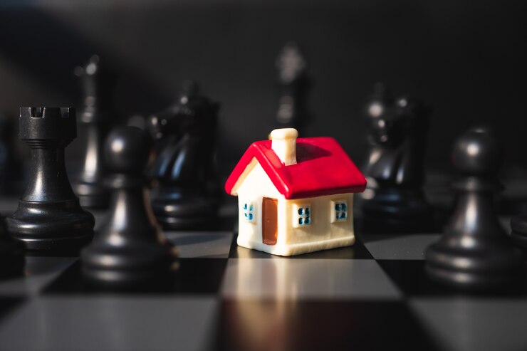 Casa miniatura sul fondo della scacchiera facendo uso di come concetto della proprietà