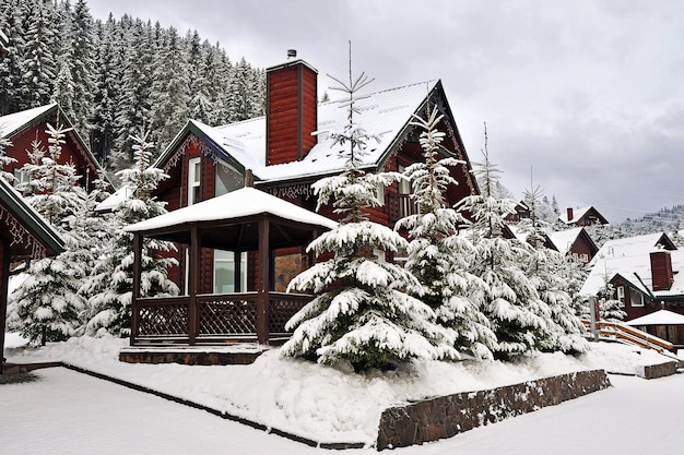 Casa per le vacanze cottage in legno in località di villeggiatura di montagna ricoperta di neve fresca in inverno.