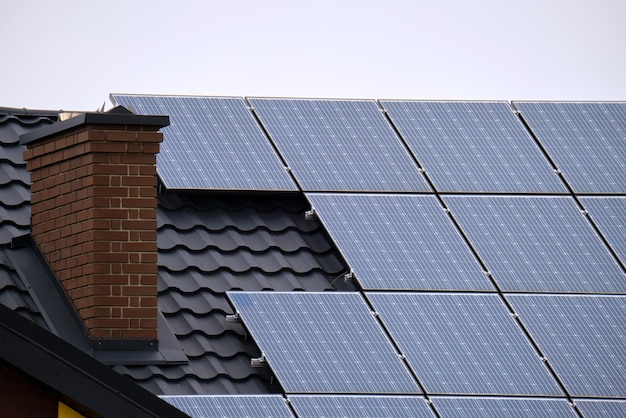 Casa residenziale con tetto ricoperto di pannelli solari fotovoltaici per la produzione di energia elettrica ecologica pulita in un'area rurale suburbana Concetto di casa autonoma