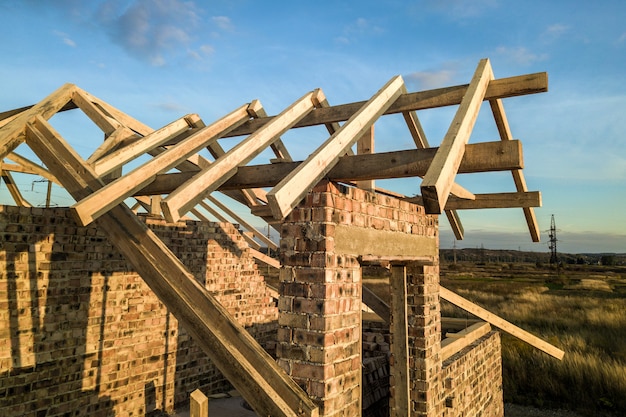 Casa residenziale privata con struttura in legno del tetto in costruzione. Edificio in muratura incompiuto in fase di sviluppo.