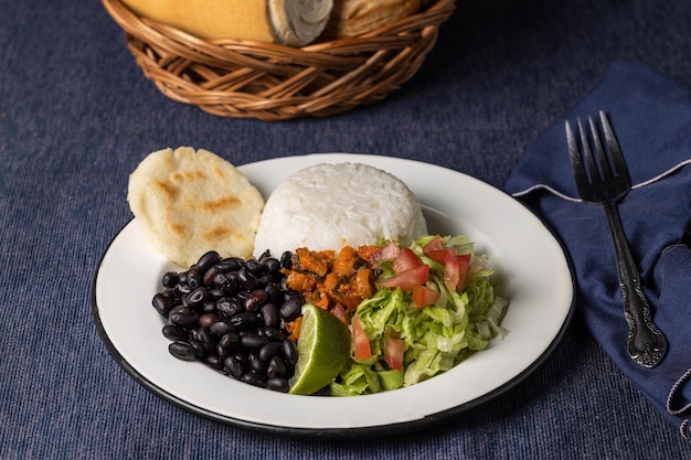 Casado tipico piatto costaricano con fagioli di riso e verdure in piatto bianco