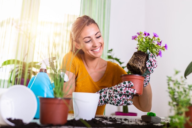 Casalinga adorabile con il fiore in vaso e insieme di giardinaggio.