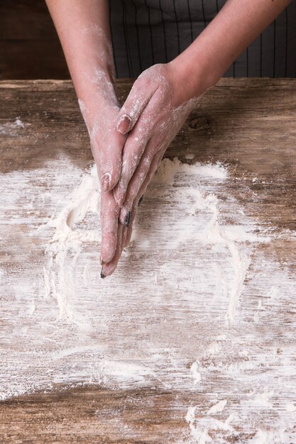 Casalinga che cuoce il pane con una ricetta di famiglia. Mani ricoperte di farina. Concetto di cucina domestica