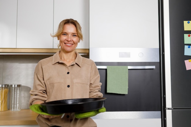 Casalinga matura con una teglia in cucina